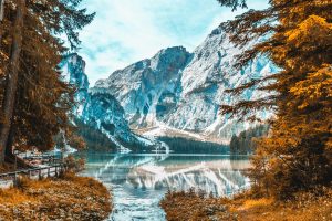 Stunning view of Lago di Braies reflecting snow-capped mountain peaks in Veneto, Italy.