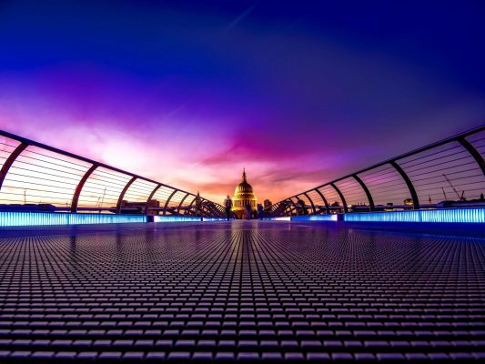 Captivating view of London's Millennium Bridge at sunset with St. Paul's Cathedral in the background.