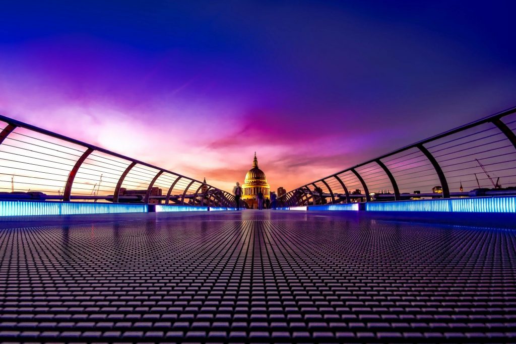 Captivating view of London's Millennium Bridge at sunset with St. Paul's Cathedral in the background.