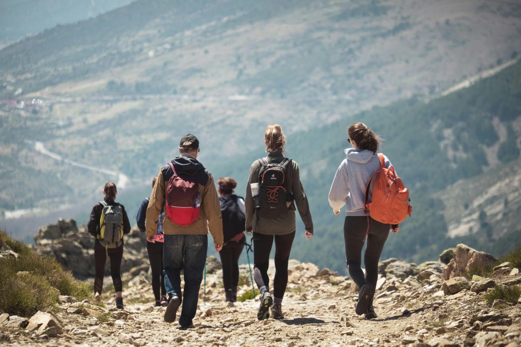 A group of people hiking along a rocky mountain trail, enjoying nature and adventure.