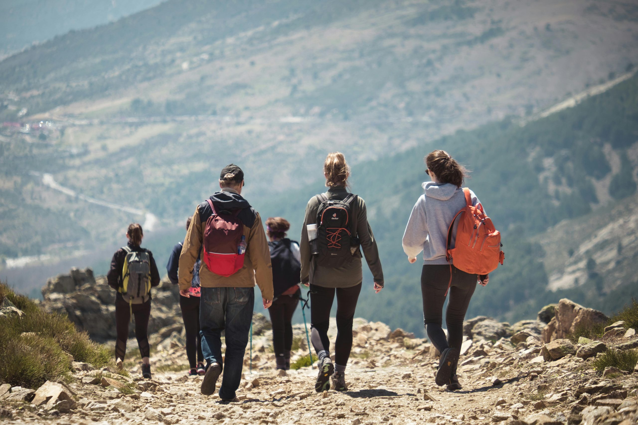 A group of people hiking along a rocky mountain trail, enjoying nature and adventure.