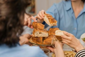 A group of people sharing freshly baked bread, highlighting warmth and community.