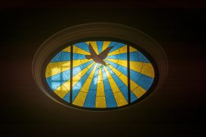 Colorful oval stained glass window featuring a dove in Teguise, Spain church.